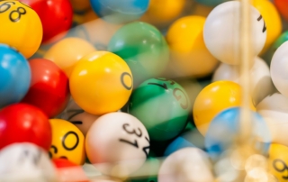 Colourful numbered bingo balls inside a metal cage.