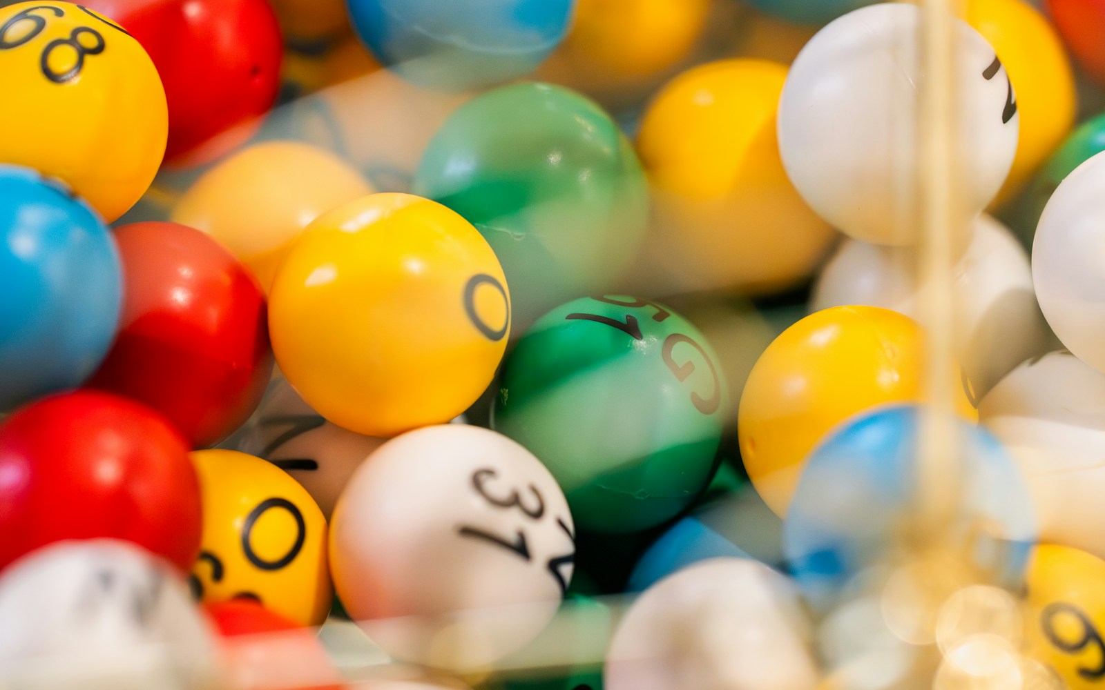 Colourful numbered bingo balls inside a metal cage.